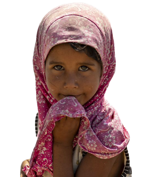 A child in a colorful outfit, smiling and sitting on a hospital bed.