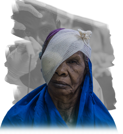 An elderly person with a bandage over one eye, wearing a blue shawl.